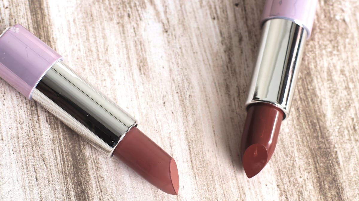 Two elegant lipsticks showcased on a wooden surface, perfect for makeup and cosmetic themes.